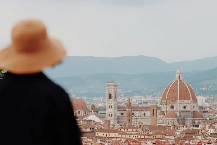 Mulher de chapéu olhando o Duomo de Florença, na Itália