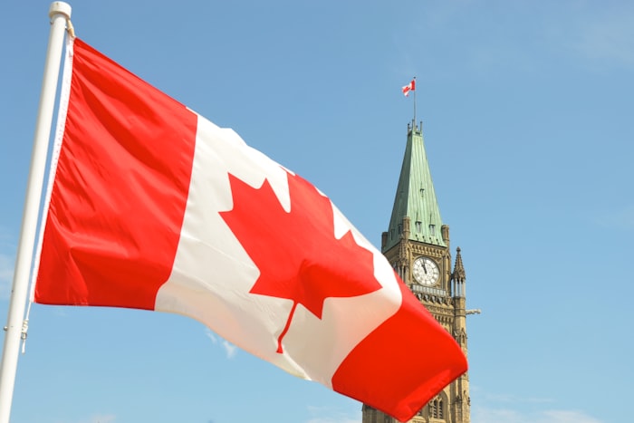 Bandeira do Canadá tremulando em frente à Torre da Paz, no Parlamento em Ottawa