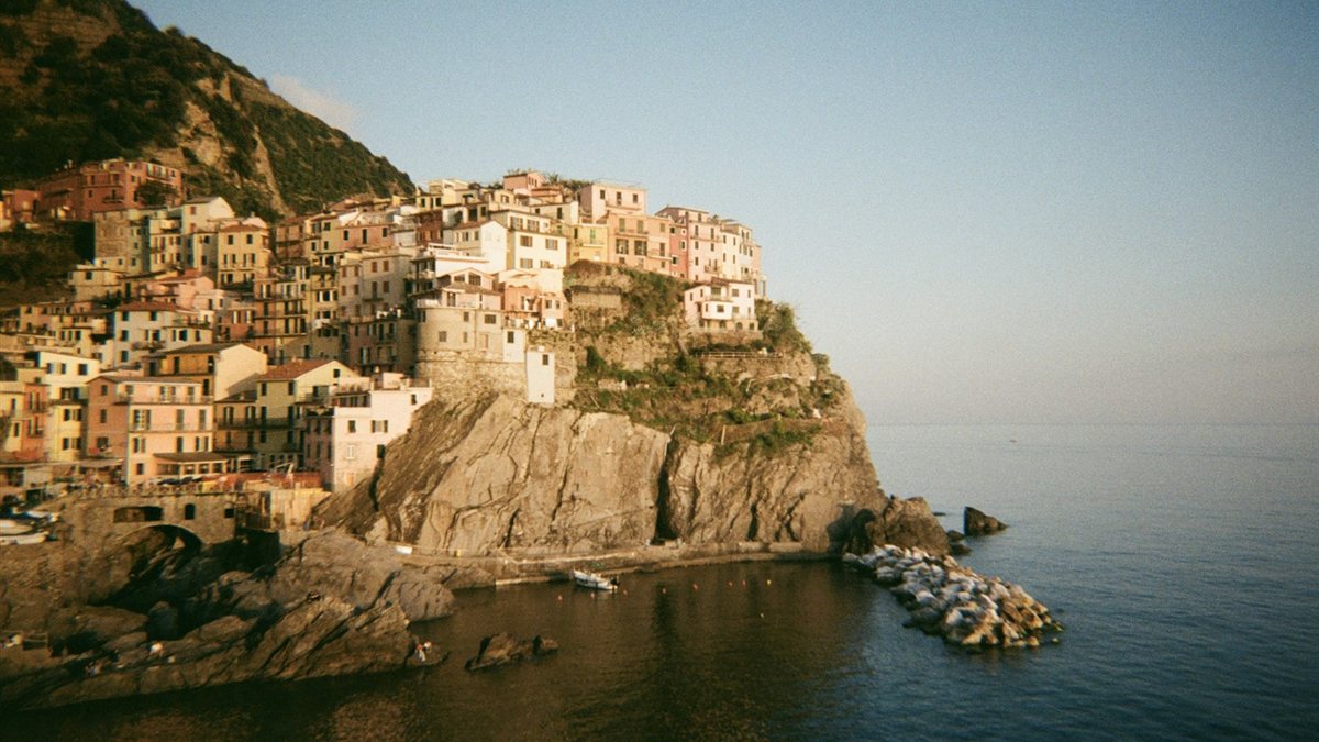 Vista de Manarola, vila colorida encravada num penhasco à beira-mar em Cinque Terre, Itália, num fim de tarde de verão