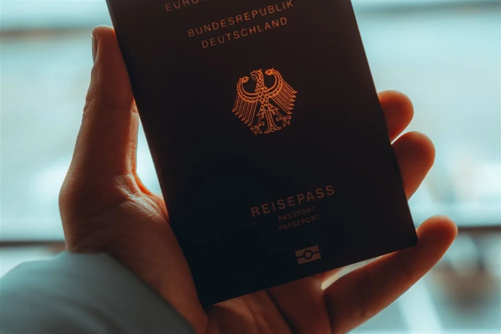 Mão segurando um passaporte alemão