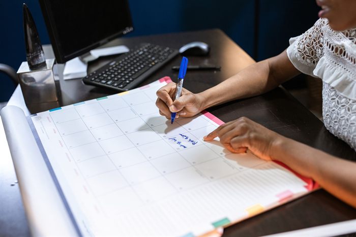 Mulher marca datas em um calendário de mesa